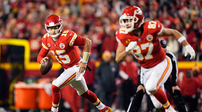 Patrick Mahomes looking to pass the ball while Travis Kelce runs a route.